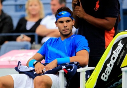 Rafael Nadal of Spain sits under an umbrella during a break in the match against Gilles Muller of Luxembourg during Day Ten of the 2011 US Open at the USTA Billie Jean King National Tennis Center on September 7, 2011 in the Flushing neighborhood of the Queens borough of New York City.  